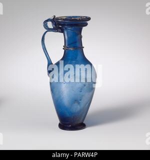 Verseuse en verre. Culture : Roman, du Rhin. Dimensions : H. : 4 1/8 in. (10,5 cm). Date : 3e et 4e siècle de notre ère. Bleu cobalt translucide ; poignée, sentier et anneau de base dans la même couleur. Rebord plié sur et dans, et lissée sur le côté de la bouche de torchage ; cou cylindrique, élargir légèrement vers le bas ; oblique ; corps bulbeux, effilé à l'anneau de base appliquée ; fond plat, avec un léger coup de pied et pontil cicatrice ; deux nervures poignée sangle fixés en haut du corps avec de longues nageoires vers le bas, à bords, élaboré et vers l'extérieur dans une courbe, puis se tourna et en dessous de la bouche traîné sur plus de trail et la lèvre décoration Banque D'Images