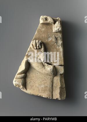 Fragment de plaque de secours avec un enfant de Dieu, inscrit sur l'arrière. Dimensions : H. 15 cm (6 in.) ; W. 9,2 cm (3 5/8 in.) ; D. 3 cm (1 3/16 in.). Date : 500-200 B.C.. Petite Période ptolémaïque et reliefs ou sculptures qui illustrent un sujet dans une façon partielle ou non fini mais sont eux-mêmes des objets finis constituent une catégorie spéciale d'objet. Comme ces lignes directrices pour les artistes sont souvent mis bien en évidence dans le cadre de l'objet, bien que, en fait, de nombreux cas peuvent être noté d'où l'objet n'a simplement pas pu servir de modèle pour une représentation égyptienne officielle traditionnelle. Personifica Banque D'Images