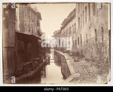 La Bièvre. Artiste : Charles Marville (français, Paris 1813-1879 Paris). Dimensions : 27,8 x 37,6 cm. (10 x 14 15/16 13/16 in.). Date : ca. 1865. Comme l'photographe officiel de la ville de Paris, Charles Marville a été accusé de documenter la transformation massive de la ville par Napoléon III et son urbaniste, Le Baron Haussmann. Au début des années 1850, l'empereur a proposé un réseau de grands boulevards qui charrue par les rues étroites et sinueuses et bidonvilles surpeuplés de Paris. Marville a enregistré la méthodiquement les rues et les bâtiments vouées à la démolition, préservant un i Banque D'Images