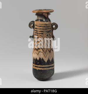 Alabastron en verre (flacon de parfum). Culture : le grec, l'Est de la Méditerranée. Dimensions : H. : 3 1/2 in. (8,9 cm). Date : fin 6ème-5ème siècle avant J.-C.. Bleu clair translucide, avec poignées de même couleur ; sentiers en jaune opaque. Télévision large jante-disque ; courte légèrement obliques ; cou cylindrique à épaulement arrondi étroit ; droit face à l'ascension du corps ; conique bas convexe marquée par l'outillage irrégulières ; tirets ci-dessous l'épaule, deux poignées anneau vertical avec queues bulbés appliqué sur un sentier décoration ; un peu plus grandes que les autres. Un chemin à bord de jante-disque ; un autre appliquées comme un blob épais Banque D'Images
