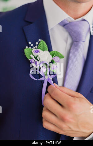 Matin, marié Marié dans une veste, le marié se redresse la boutonnière, jour de mariage. Banque D'Images