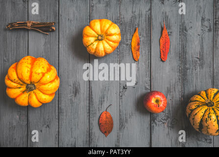 Composition d'automne avec du potiron, pomme et des feuilles sèches sur fond de bois rustique Banque D'Images