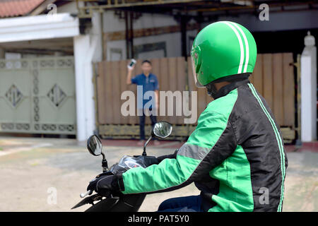 Taxi moto homme s'est approché le passager à l'avant de la maison Banque D'Images