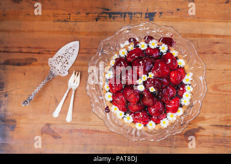 Gâteau aux fraises fait maison avec du jus de raisin rouge glaçage et décoration fleur daisy sur vieux cake stand Banque D'Images