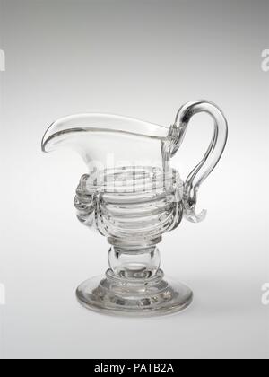 Pichet de crème. Culture : L'Américain. Dimensions : 6 1/16 x 5 9/16 in. (15,4 x 14,1 cm). Bouilloire : attribuée à New England Glass Company (Américain, East Cambridge, Massachusetts, 1818-1888) ; peut-être en verre de South Boston fonctionne. Date : 1815-35. Verre, couper finement gravés ou dans une variété de modèles basés sur les styles Régence anglaise, a été en vogue pour un art de la table au début du xixe siècle. Cet élégant pichet de crème et son bol de sucre révèlent une alternative à la découpe : la manipulation de la liquide clair, le verre dans son état fondu. Les navires de la moissonneuse-batteuse multipl Banque D'Images