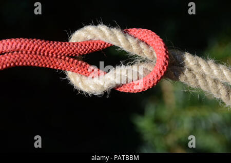 Nœud plat sur une corde de chanvre et de cordage en nylon rouge.