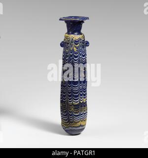 Alabastron en verre (flacon de parfum). Culture : l'Est de la Méditerranée ou l'italien. Dimensions : H. 7 3/8 in. (18,7 cm). Date : fin 4ème-début du 3e siècle avant J.-C.. Bleu cobalt translucide, avec poignées de même couleur ; sentiers en jaune opaque et blanc opaque. Large rebord légèrement inégale-disque, faites comme une spirale autour de la partie supérieure de la bobine cylindrique ; cou cou, effilé vers le bas ; l'épaule anguleuse ; corps cylindrique rectiligne, avec légère conicité convexe ; bas ; sur le haut du corps, deux poignées anneau vertical, appliquée sur schéma, un sentier un peu plus haut que l'autre. Un sentier jaune attaché à bord de jante- Banque D'Images