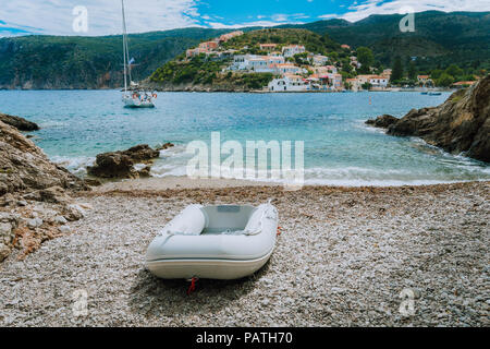 Un canot sur la petite plage cachée à Assos village. Yacht blanc à Assos bay. Grèce Céphalonie Banque D'Images