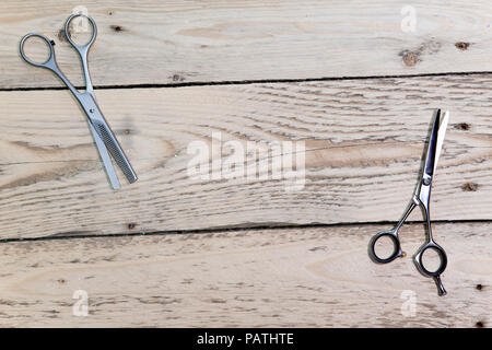 Salon de coiffure ciseaux, peigne et brosse, le pulvérisateur pour les cheveux s'allonger sur une planche en bois Banque D'Images