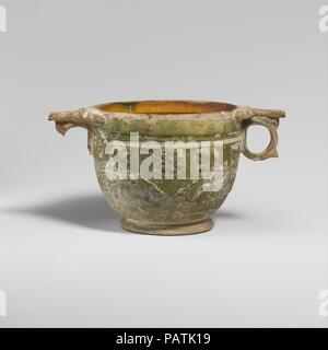 Tasse en terre cuite (scyphus). Culture : Roman. Dimensions : H. 2 15/16 in. (7,49 cm). Date : 1ère moitié du 1er siècle de notre ère. Vitrage vert tasse avec vaporisateurs floral en relief. Musée : Metropolitan Museum of Art, New York, USA. Banque D'Images