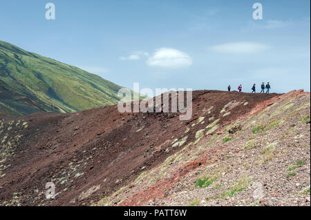 Les touristes marchant sur le bord d'un cratère près de Rifugio Sapienza, un véhicule s'arrêter sur le mont Etna, en Sicile. Banque D'Images