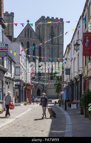 Kirkgate, une étroite rue pavée, avec une vue sur la face ouest de la cathédrale à la fin ; Ripon, North Yorkshire, UK Banque D'Images