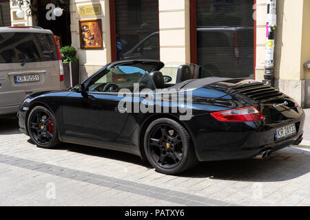 Une Porsche noire Carrara 4s transformable en stationnement sur une rue de Cracovie, Pologne, Europe. Banque D'Images