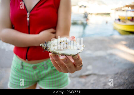 Girl holding en main ouverte. d'huîtres et fruits de mer de la rue au Monténégro Banque D'Images