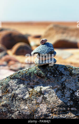 Pyramide des vieilles pierres avec un beau lichen sur une plage de la mer Baltique sur une journée ensoleillée Banque D'Images