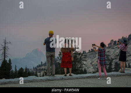 Yosemite National Park, California, USA. 24 juillet, 2018. Le Mardi, Juillet 24, 2018.Yosemite National Park les visiteurs de prendre des photos à Olmsted Point le long de Tioga Pass Road et l'autoroute 120 dans le haut pays du parc. Demi Dôme est vu dans l'arrière-plan à travers la fumée des incendies Ferguson. Le feu brûle près de l'entrée du parc El Portal. Credit : Tracy Barbutes/ZUMA/Alamy Fil Live News Banque D'Images