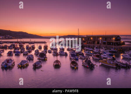 Lyme Regis, dans le Dorset, UK. 25 juillet 2018. Météo France : Golden sunrise à Lyme Regis. Les bateaux dans le port sont découpé sur la lumière dorée du petit matin ciel sur une autre journée chaude et ensoleillée dans la station balnéaire ville de Lyme Regis. Credit : Celia McMahon/Alamy Live News. Banque D'Images