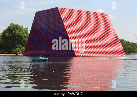 Hyde Park. Londres. Royaume-uni 25 juin 2018 - Les touristes dans un bateau dans le lac de plaisance de Hyde Park en face de l'un mastaba Londres 20 mètres de haut comprenant 7 506 barils de sculptures peintes par Christo flottant sur le lac Serpentine, à Hyde Park sur une journée très chaude et humide dans la capitale. D'après le Met Office la température de Londres et du sud-est est susceptible d'atteindre 35 degrés celsius le jeudi. Credit : Dinendra Haria/Alamy Live News Banque D'Images