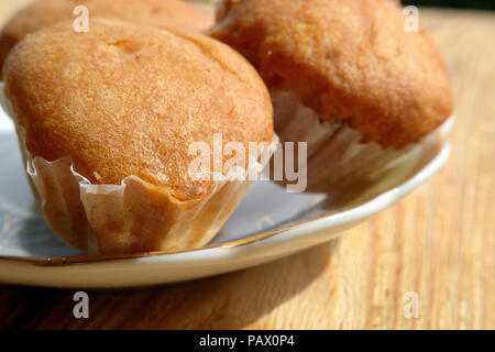 Muffins sur une plaque sur fond de bois Banque D'Images