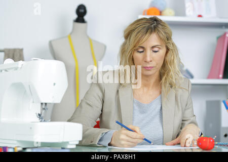 Portrait de femme à l'aide de la machine à coudre électrique Banque D'Images