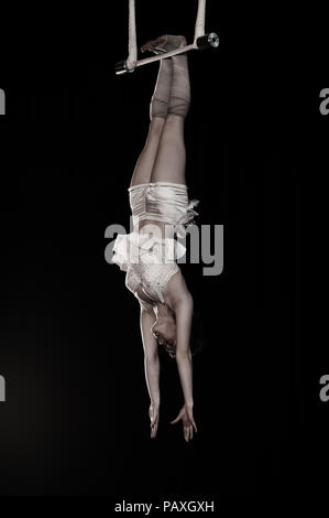 Carly est une trapéziste suspendu à ses pieds. Les élèves de l'Institut National des Arts du Cirque ont des talents exceptionnels. Banque D'Images
