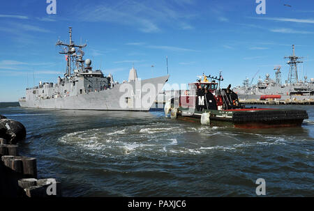 Un remorqueur remorque l'USS Nicholas. La classe Oliver Hazard Perry frégate lance-missiles USS Nicholas (FFG 47) est tiré hors de la jetée 4 à la Naval Station Norfolk pour faire place à d'autres navires en partance. Banque D'Images