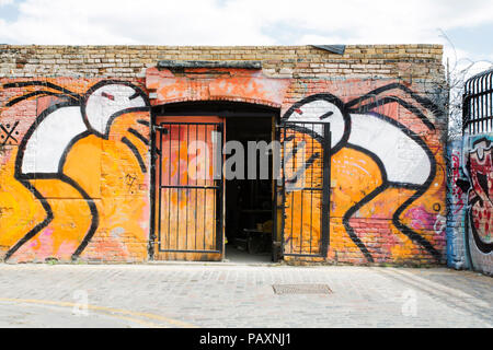 Deux hommes des vomissements au cours d'une porte avant, un graffiti par Stik dans Brick Lane. Londres. 2018 Banque D'Images