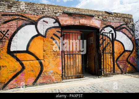 Deux hommes, des vomissements, un graffiti sur une porte avant par Stik dans Brick Lane, East London. 2018 Banque D'Images