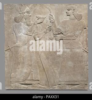 Panneau de secours. Culture : l'assyrien. Dimensions : 92 x 92 1/4 x 4 1/2 in. (234,3 x 233,7 x 11,4 cm). Date : ca. 883-859 av. J.-C.. Cet allégement, du palais du roi assyrien Assurnazirpal II (r. ca. 883-859 avant J.-C.), dépeint un roi Assurnazirpal, probablement lui-même, et d'un accompagnateur. Les deux plus grandes que nature, les chiffres de taille moyenne sont sculptées en bas relief, et qu'avec d'autres reliefs dans le palais avec l'image du roi, la sculpture est particulièrement belle et montre une attention particulière aux détails. Le groupe se joint à une deuxième soulagement que montre un autre accompagnateur, face aussi à la king, et un surnaturel ailé p Banque D'Images