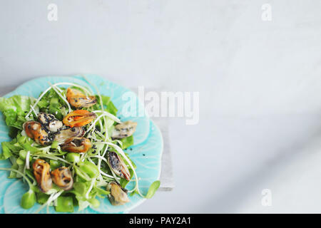 Salade Thaï aux moules, fond clair avec copyspace. Banque D'Images