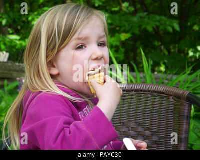 Une petite fille (3 ans) de manger une glace Banque D'Images