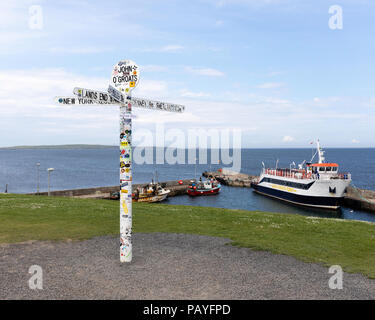 Le poteau de signalisation indiquant la fin de la route, à John O'Groats avec les administrations portuaires, Ferry et Orkeney dans l'arrière-plan Banque D'Images