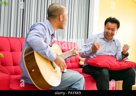 Deux gars sont asiatiques à jouer de la guitare, instrument de musique professionnels et sourire sentiment. Banque D'Images