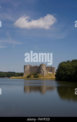 Seul nuage blanc assis au-dessus du château de Carew et sa réflexion sur une chaude après-midi d'été Banque D'Images