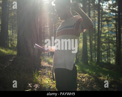 Portrait de jeune homme dans la forêt de remue-méninges avec bloc-notes papier prise de notes concept éducation Banque D'Images