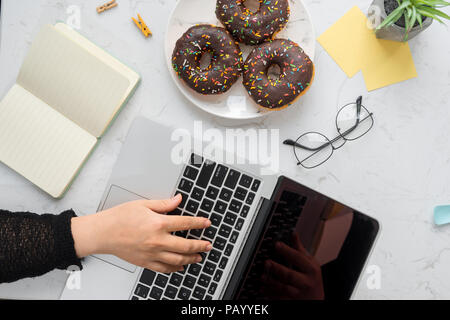 Tasse de café et beignes avec ordinateur Banque D'Images