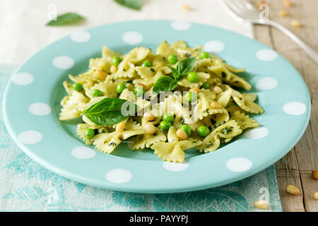 Les Pâtes au pesto, les pois verts et basilic sur une table en bois. De style rustique, selective focus. Banque D'Images