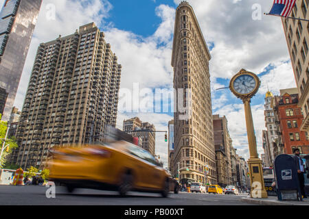 Des vitesses d'obturation d'un taxi jaune new york avec le célèbre Flat Iron Building en arrière-plan, New York City, USA Banque D'Images