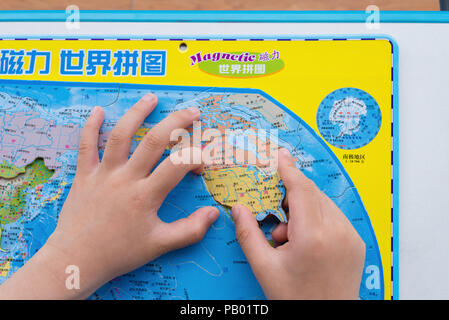 China-April,Zhongshan 15,2018:kid jouer puzzle carte du monde et de mettre les États-Unis dans la position correcte. Banque D'Images