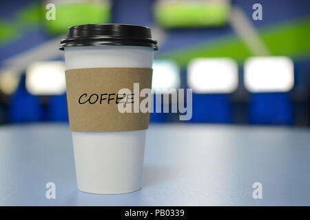 Papier blanc avec couvercle tasse café noir avec de l'étiquette de votre texte derrière sporty bleu vert arrière-plan flou Banque D'Images
