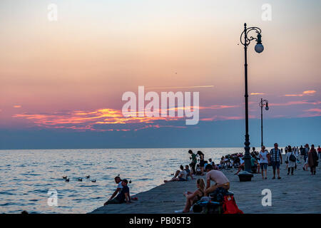 Trieste, Italie, 25 juillet 2018. Les gens profiter du coucher du soleil à partir de l'emblématique Molo Audace Audace (Pier) dans le nord de l'Italie ville de Trieste. Le 246-mete Banque D'Images