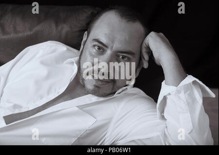 Studio noir et blanc portrait d'un homme en chemise blanche Banque D'Images