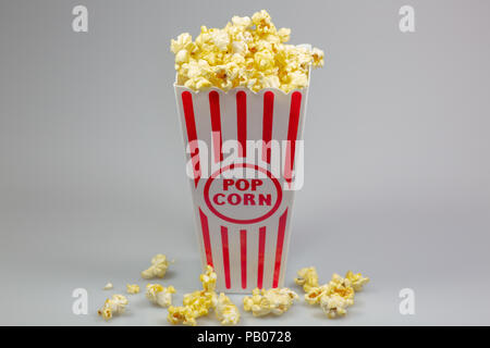 Un déshabillé rouge petit seau de popcorn popcorn débordant de sur un compteur blanc Banque D'Images