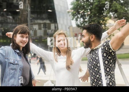 Trois amis avec leurs bras autour de l'autre d'écouter de la musique Banque D'Images