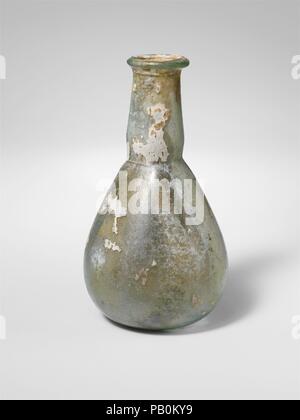 Flacon de parfum en verre. Culture : Roman. Dimensions : hors tout : 4 1/4 x 2 7/16 x 1 in. (10,8 x 6,2 x 2,5 cm). Date : 1er et 2e siècle de notre ère. Lumière pâle Translucide bleu. De plus, Rim, et dans, aplati sur le dessus ; le cou en forme d'entonnoir avec côtés bombés légèrement remanié et tiret autour de base ; corps ovoïde ; fond Glénat. Complète, mais se fissurer autour du cou juste au-dessous de la jante et d'autres fissures verticales dans le cou et le corps, d'autres bulles piqûre ; ternissement, s'évanouir, l'iridescence et de parcelles de l'altération d'un blanc crémeux sur l'extérieur, l'incrustation et l'altération du sol blanchâtre sur l'intérieur. Musée : Metropolita Banque D'Images