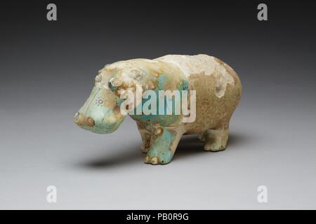 Hippopotame. Dimensions : h. 9 cm (3 9/16 po) ; w. 18,5 cm (7 5/16 po). Dynastie DYNASTIE : 12-13. Date : ca. 1981-1650 av. J.-C.. Statuettes d'hippopotame en faïence (un non-argile céramique) se produire dans quatre positions différentes : se tenir debout, marcher, assis, et inclinables. La surface de l'hippopotame marche ici est peinte avec la plus commune motif décoratif pour ces figurines, ouvert et fermé des fleurs de lotus et lotus feuilles. En plus d'une grenouille est représenté sur chacun des quartiers arrière de l'hippopotame. La glaçure de faïence a décoloré avec le temps et ce qui était autrefois une lumière bleue s'est évanoui d'un très ligh Banque D'Images