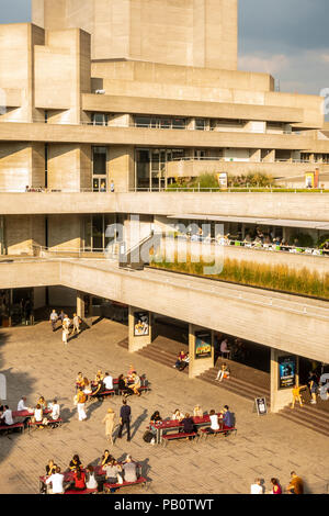 Les touristes et les habitants bénéficiant d'un bain à l'extérieur de la soirée Juillet architecture brutaliste concrètes du National Theatre de Londres, UK Banque D'Images