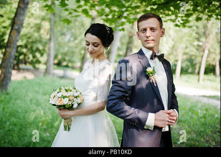 Couple de Mariage fabuleux et s'étreindre dans le parc sur une belle journée d'été. Banque D'Images