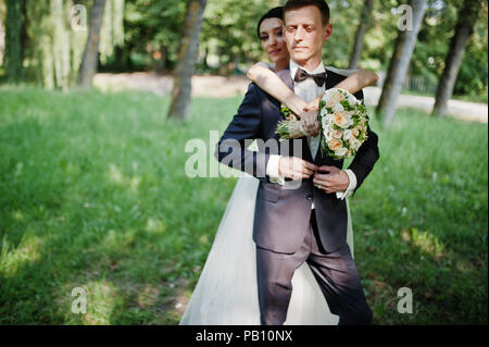 Couple de Mariage fabuleux et s'étreindre dans le parc sur une belle journée d'été. Banque D'Images