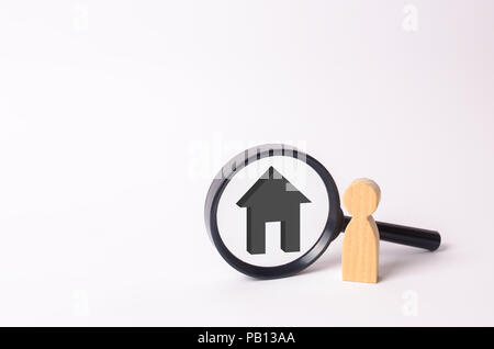 Figures en bois de personnes se tenir près de la loupe avec une maison grise. La famille est à la recherche de quelque chose. Le concept de recherche de logement. Market Banque D'Images